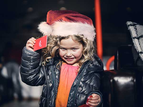 Little girl in a santa hat with a Josie key card.