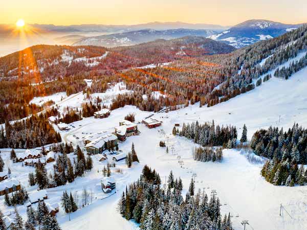 Aerial view of The Josie hotel and ski slopes in the snow.